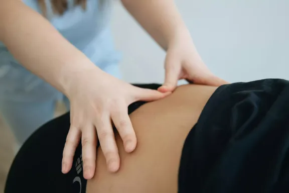 Fisioterapeuta realizando ejercicios en la espalda de una paciente